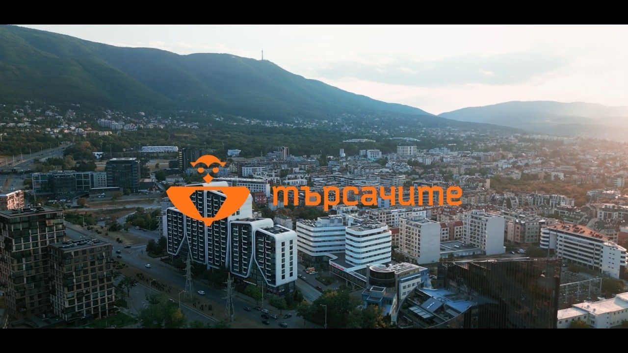 Кадър от видеото за мисията: изглед към град с логото на Школа Търсачите